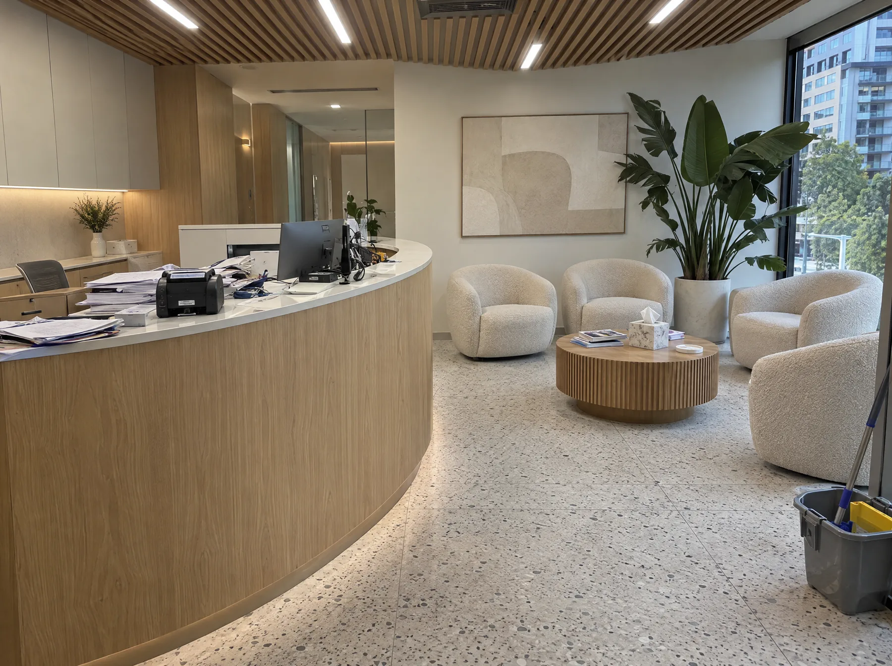 Before: a dental clinic reception with paperwork piled on the desk and a mop bucket