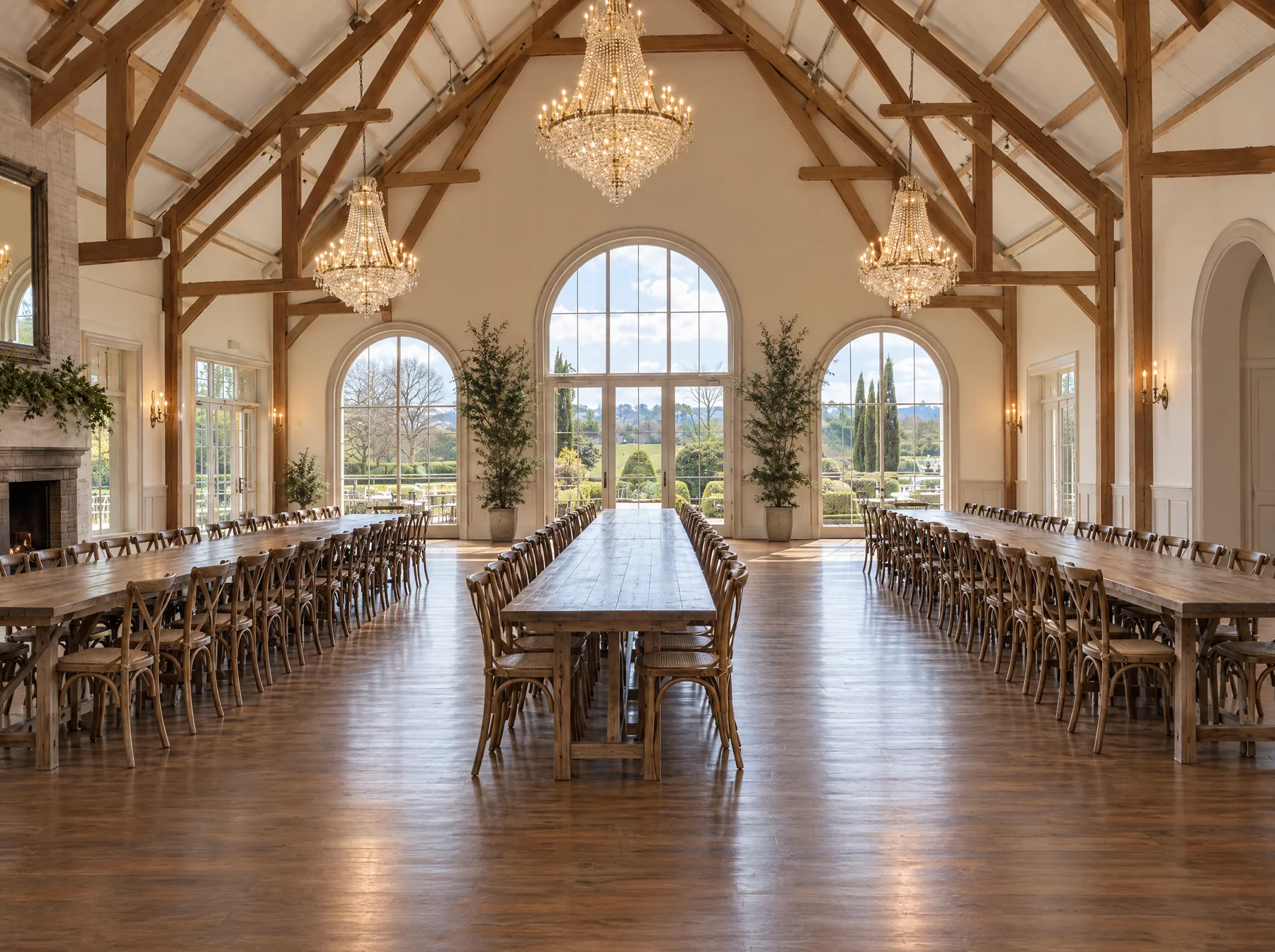 After: the same barn venue with long tables fully set beneath the chandeliers